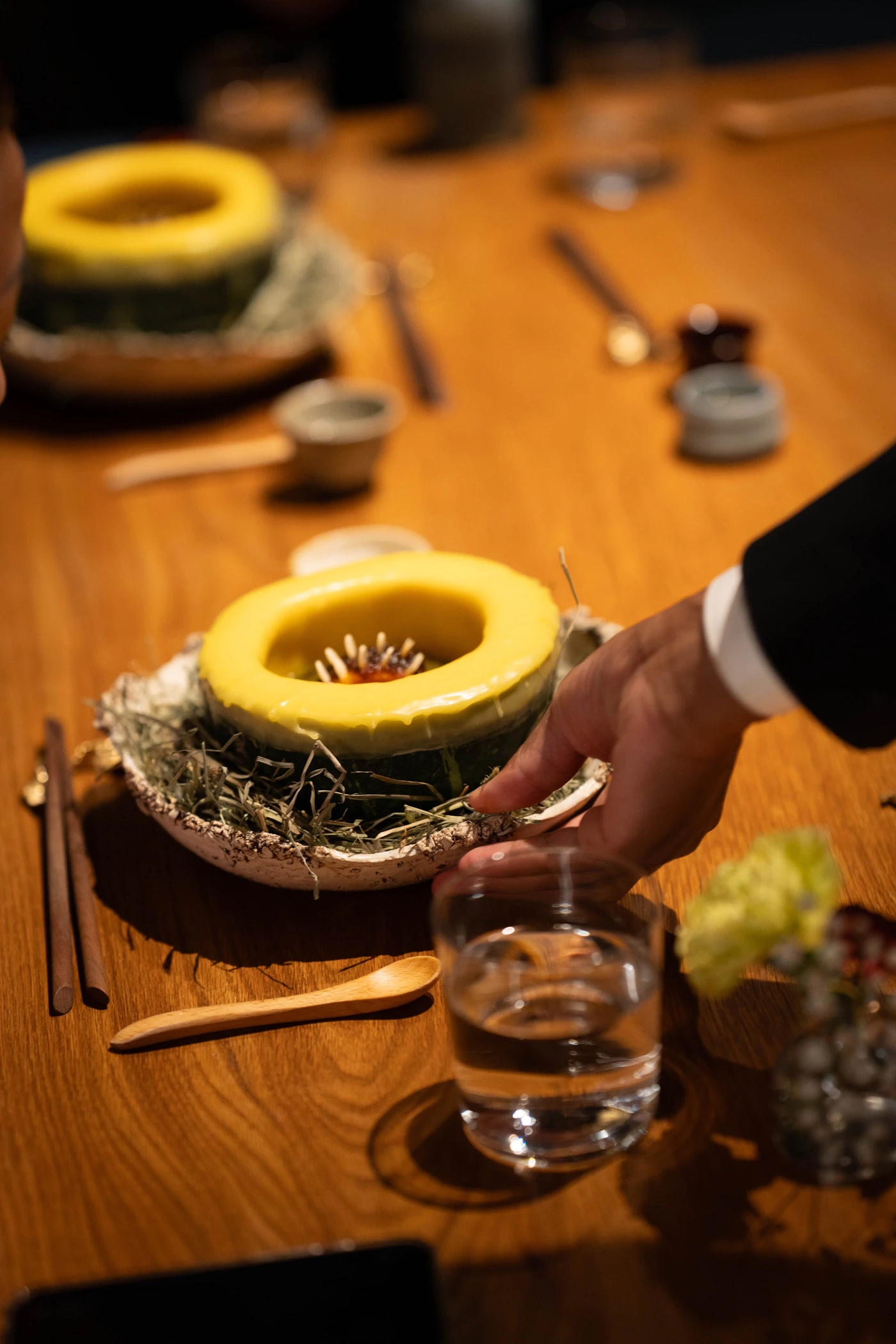 Server placing a composed appetizer on a restaurant table